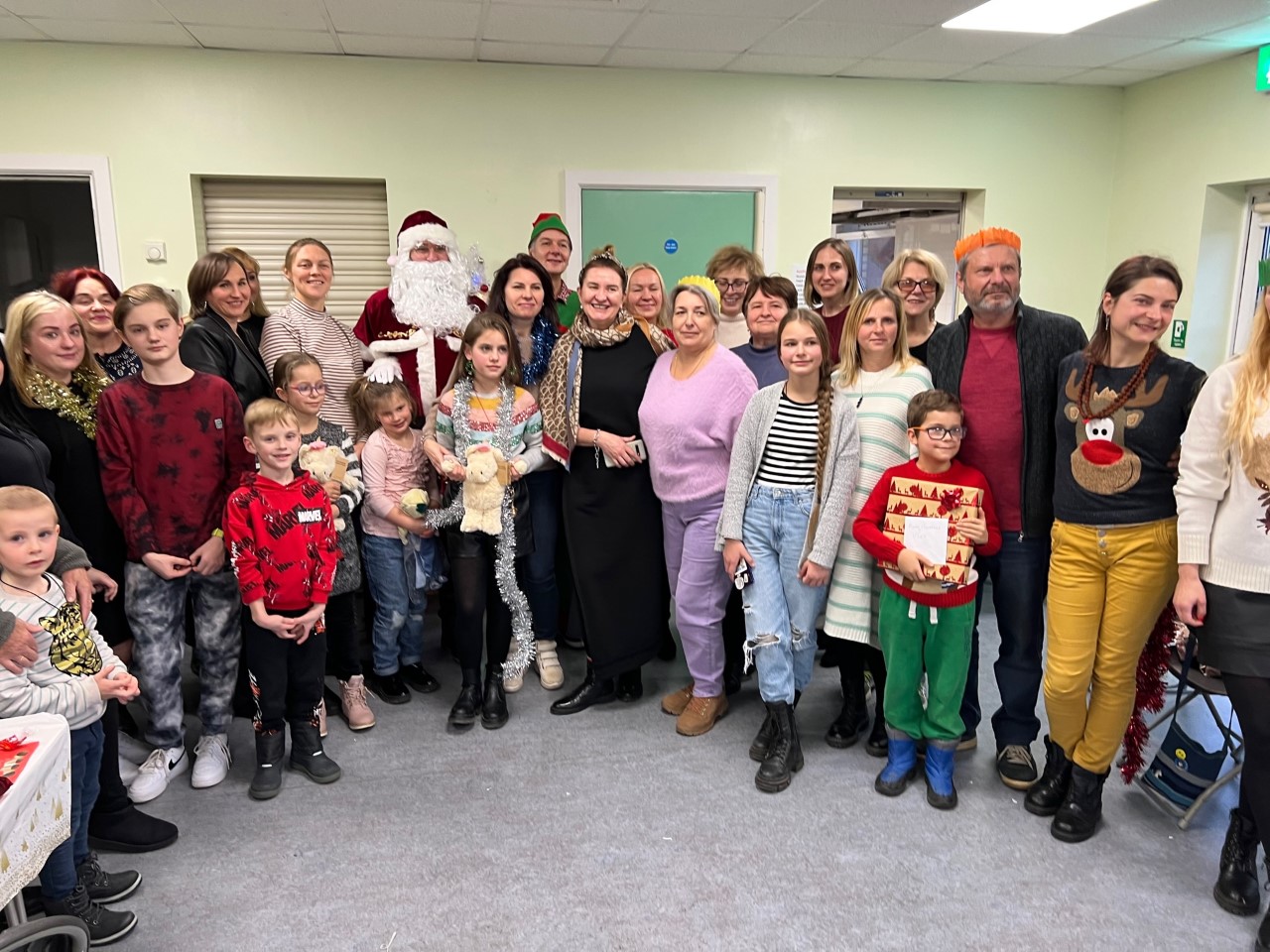 Photo of happy Ukrainian Guest at The Care Forum's Christmas meal with Santa and an Elf.